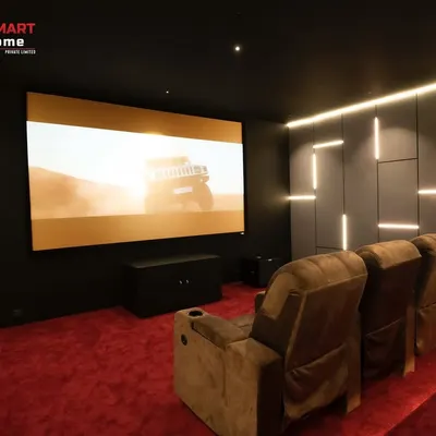 A view from the back of a 9.1.4 luxury home cinema in Thirunagar, Madurai. The massive 150-inch Elite Screen is perfectly paired with an Optoma projector, delivering a crystal-clear 8K picture.