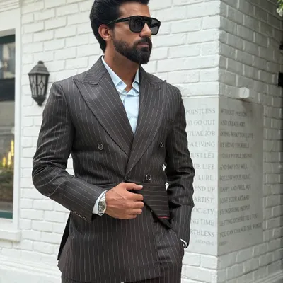 Our pinstripe double-breasted suit is the epitome of sartorial excellence. The sharp peak lapels and structured shoulders create a powerful and confident look for any business or formal occasion.