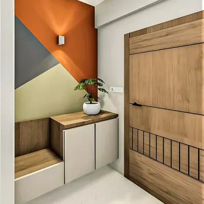 A modern entryway featuring a geometric color-block accent wall. The space includes a floating cabinet and a built-in wooden bench, combining bold design with practical function.