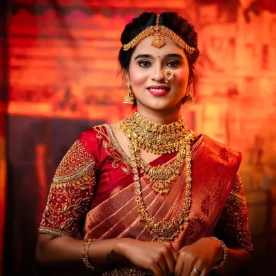 A close-up of our classic red bridal saree look, showcasing the intricate temple jewellery set available for rent. We ensure every bride gets a complete, perfectly coordinated look from head to toe.