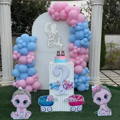 A complete gender reveal party setup with an "Oh Baby" neon sign. This outdoor decoration includes a "Boy or Girl?" pedestal, cute baby cutouts, and a pink and blue balloon arch against a white backdrop.