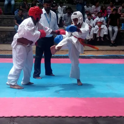 A moment of perfect execution. A student lands a kick in a youth competition. This is the result of countless hours of practice in the dojo.
