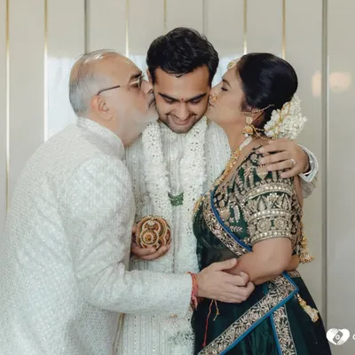 The purest form of love. The groom receives kisses from his proud parents on his wedding day. These are the moments that fill our hearts.