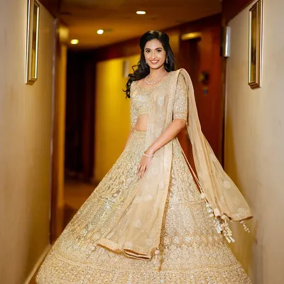 A full-length portrait of the bride, Shalmali, twirling in her gorgeous golden lehenga.
