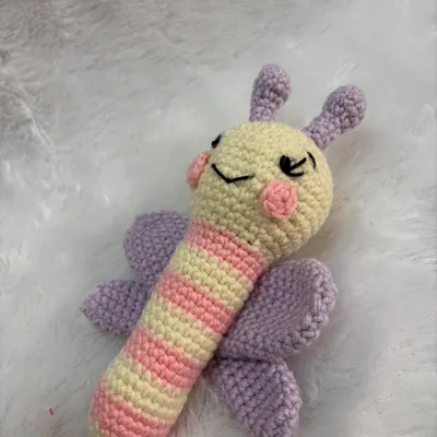A gentle and colorful butterfly baby rattle. The wings and striped body are designed to be visually stimulating for a newborn.