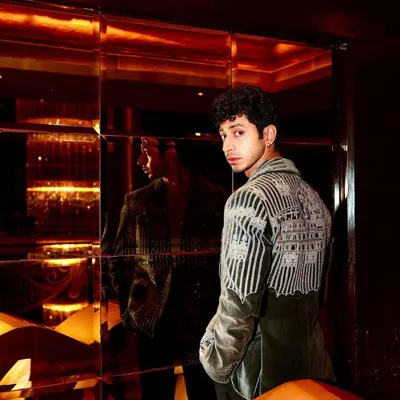 Mihir Ahuja in my grey velvet coat, a piece defined by its intricate hand embroidery. This back view shows the detailed craftsmanship that covers the shoulders and sleeves, creating a wearable work of art.