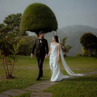 Irene and Siril's walk through a misty, green landscape after their hilltop Christian wedding. This shot captures the fairy-tale romance and serene beauty of their special day.