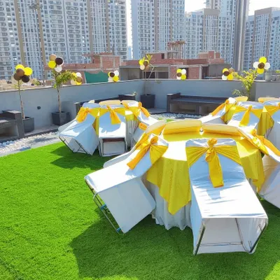 This was a birthday celebration on a rooftop. I provided the complete seating arrangement with tables and chairs, using a yellow and black color theme for the covers and balloons.