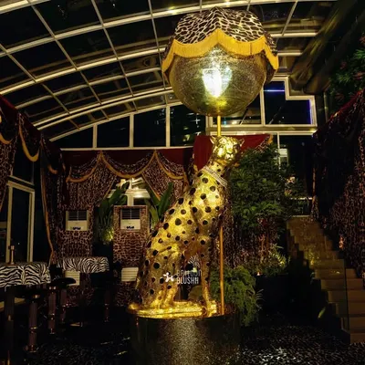 The 'Gilded Instinct' theme in full view. This Roberto Cavalli inspired design features a life-sized golden cheetah, animal-print drapes, and dramatic lighting to create an atmosphere of untamed luxury.