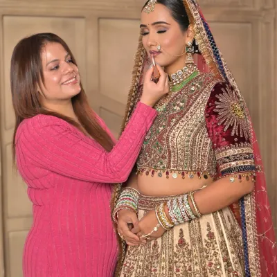 A behind-the-scenes moment where I am giving the final touch-ups to the bride's lips. It's these small details that perfect the entire look.
