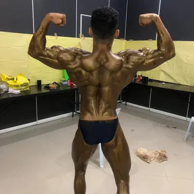 A back double biceps pose from backstage at the Mr. Asia 2019 competition. This pose is critical for showing back width, density, and hamstring definition.