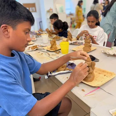 A young boy completely absorbed in sculpting his own Ganesha idol from clay. Our clay workshops are a fantastic, tactile experience for kids.