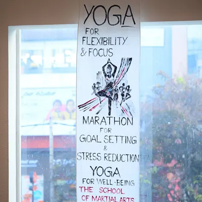 A handmade banner for our Yoga and Marathon programs, highlighting their benefits for flexibility, focus, and goal setting. We believe in a holistic approach to wellness that complements martial arts training.