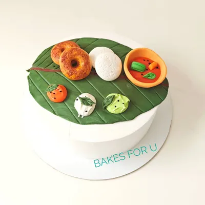 A unique cake designed to look like a traditional South Indian meal served on a banana leaf. Every element, from the idli and vada to the sambar and chutneys, is handcrafted from edible fondant.