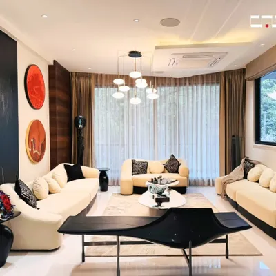This living room combines classic elegance with modern comfort. The curved sofas, statement artwork, and layered lighting create a sophisticated yet welcoming space for hosting guests.
