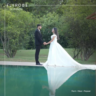 Create magical, reflective moments during your pre-wedding shoot. This couple looks serene by the pool, with him in a classic black suit and her in a beautiful white rental gown.