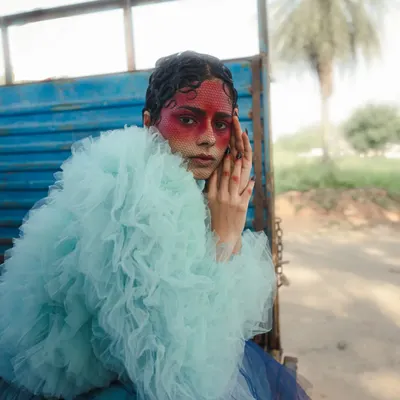 A shot from my 'Serpent' series, where we used voluminous tulle and bold, theatrical makeup to explore themes of transformation and grace. The juxtaposition of the delicate fabric with the rustic truck creates a compelling visual contrast.