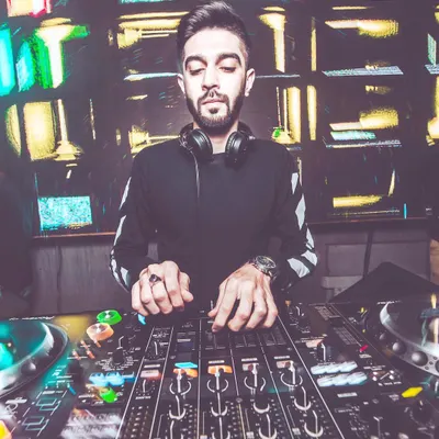 A stylized shot of me fully absorbed in the mix, with the colorful lights of the DJ console reflecting my focus. This is where I blend different sounds to create the perfect party tracklist.