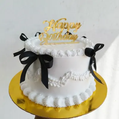 A beautiful vintage-style cake with delicate white piping and black ribbons. This classic and elegant design is perfect for any celebration.