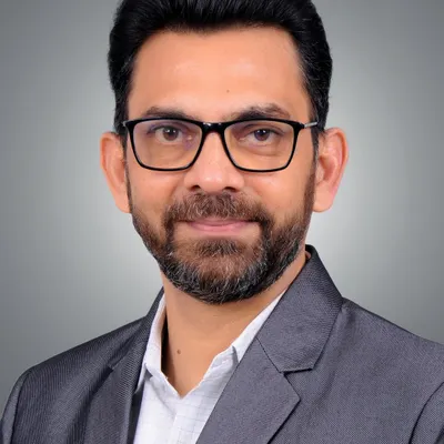 A classic corporate headshot designed for maximum clarity and a professional appearance. The balanced lighting and neutral grey background make this a versatile choice for any business use, from team pages to speaker profiles.