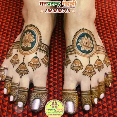 A unique and modern foot mehndi design featuring lotus mandalas and hanging jhumki (earring) motifs. The use of color makes this design truly stand out.