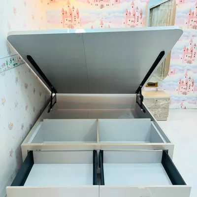 This image reveals the smart storage solutions built into our custom beds. This model features both easy-access front drawers and a large hydraulic lift-up compartment, maximizing under-bed storage space.