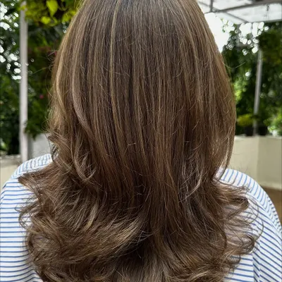 Sometimes all you need is a color refresh. Here, I blended in new highlights to brighten up her look and gave her a fresh cut with bouncy layers.