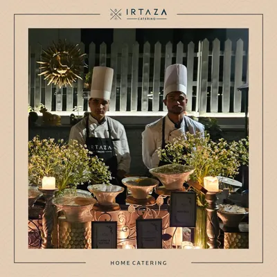 Two of my chefs in their full uniform, ready for service at a home catering event. Their professionalism is a core part of the Irtaza promise.