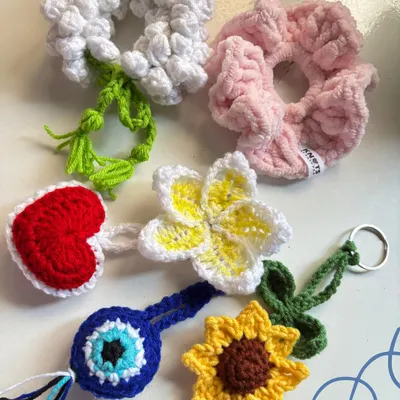 A flat lay of some of the small crochet items I made this week, including scrunchies, keychains, and charms.