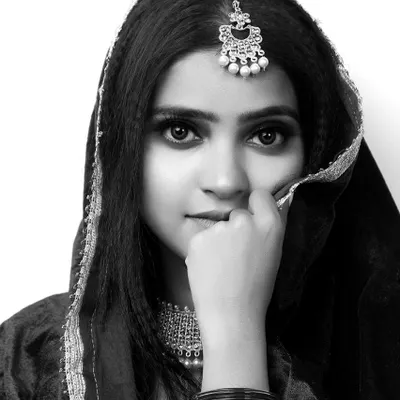 A striking black and white portrait of a model in traditional attire. This type of headshot is essential for a portfolio, showcasing strong expressions and features.