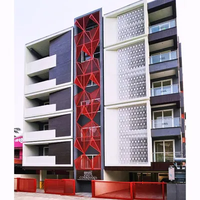 Our "Project R.E.D" in Vellore features a striking red geometric facade made of expanded metal mesh. This design choice gives the residential building a unique identity and functional screening.