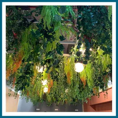 This lush, multi-layered hanging installation creates the feeling of a dense jungle canopy. We used a variety of artificial ferns, vines, and colorful foliage to build a rich, textured overhead garden that transforms the entire atmosphere of the space.