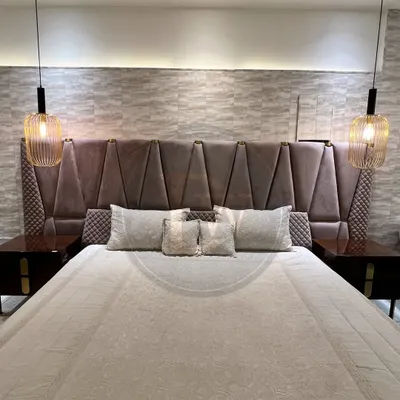 This bed makes a grand statement with its extra-tall, geometrically panelled headboard. Paired with dark wood side tables and modern pendant lights, it creates a dramatic and luxurious focal point.