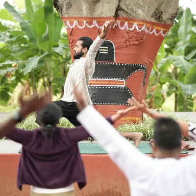 Leading a morning yoga session outdoors. This posture, a variation of a lunge, opens up the chest and shoulders, countering the effects of hunching over a desk. The participants mirror the movement, creating a sense of unity.