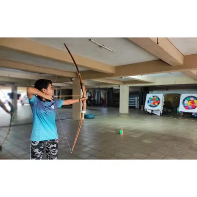 A student from our basic course practices her form with an Indian Bow. We start with fundamentals like stance and anchor point to build a strong foundation.