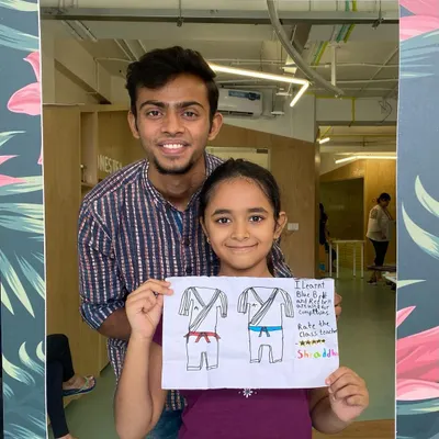 I love incorporating creative activities into our camp. Here I am with a student who just finished her drawing of karate uniforms. It helps reinforce what they learn in a fun, artistic way.