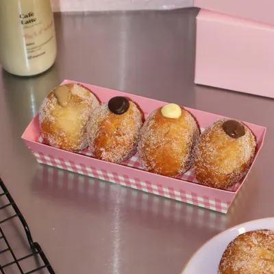 Our assorted Bomboloni Box is the perfect weekend treat. This box of four features fluffy, sugar-dusted Italian doughnuts filled with a variety of creamy custards and chocolates.