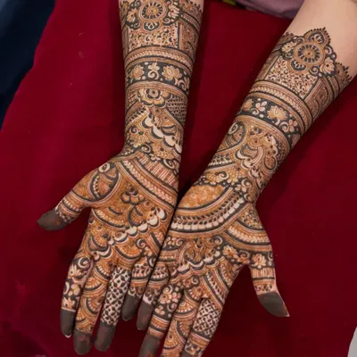 An inspiration photo for engagement mehendi, featuring beautiful, flowing patterns that extend up the arm.