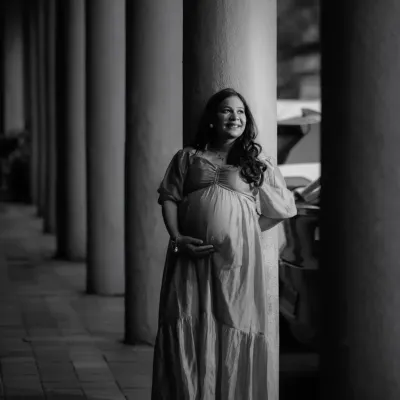 A timeless black and white maternity portrait. Stripping away the colour allows the focus to be purely on her joyful expression and the beautiful form of her pregnancy, framed by the classic pillars.