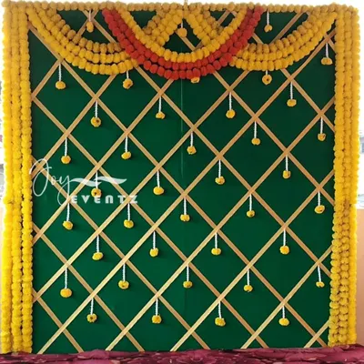 This traditional backdrop is perfect for an Indian baby shower or Seemantham ceremony. The design features a green background with a golden lattice pattern, framed by auspicious yellow marigolds.
