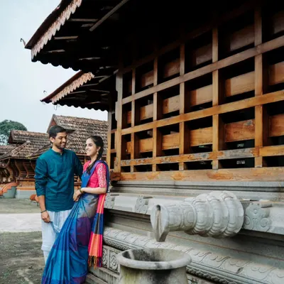 A quiet moment shared between the couple during their traditional pre-wedding shoot. The classic architecture of the Karavali region provides a stunning backdrop for their love story.