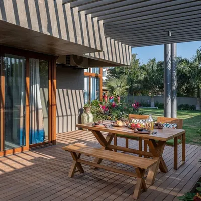 We designed this wooden deck as a true extension of the interior living space. The overhanging architectural element provides partial shade, creating a comfortable spot for outdoor dining right next to the garden.