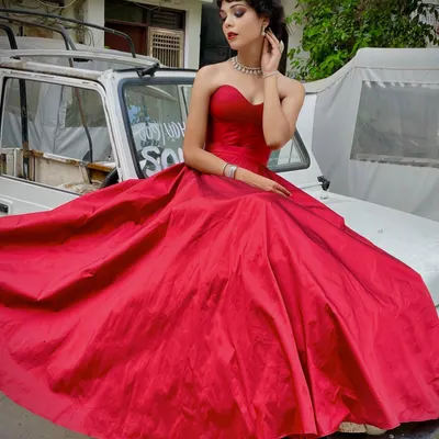 This stunning red ball gown is designed to make an entrance. The structured sweetheart neckline and voluminous skirt create a classic Hollywood-inspired silhouette, perfect for a grand reception or formal event.