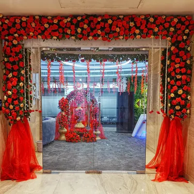 A grand entrance sets the stage for a memorable event. This doorway, framed with an abundance of red and peach roses and accented with sheer red fabric, created a dramatic and romantic entryway for a special office celebration.