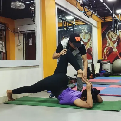 In personal training, I provide hands-on assistance to help you find the correct alignment in challenging poses, like this supine leg stretch, ensuring you get the maximum benefit safely.