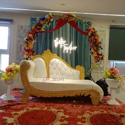 This is my complete engagement stage setup. It features an ornate white and gold sofa for the couple, a colorful floral arch, and a 'Better Together' neon sign for a modern, romantic touch.
