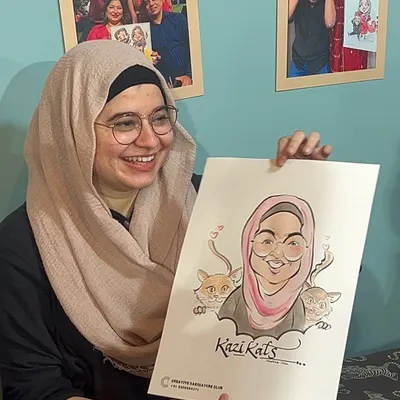 A happy client holds her finished caricature, which even includes her beloved cats. This is what my live event service is all about: creating personal, joyful art that people can take home.