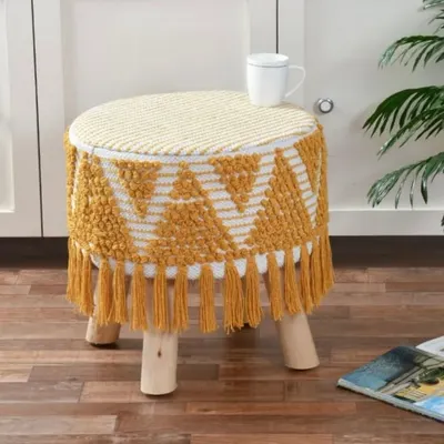This four-legged boho stool with a mustard yellow macrame cover and fringe details is both stylish and sturdy. It's a versatile piece that can be used as a small side table, footrest, or extra seating.
