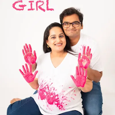 It's a girl! Gender reveal shoots are such a fun and exciting way to share your big news. The pink handprints on the baby bump are a creative and personal touch.