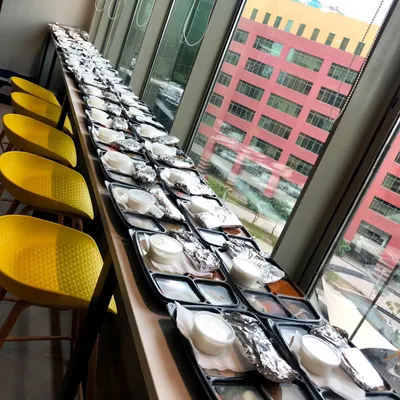 Fueling productivity with our corporate catering service. Here is a large order of packed meal trays being prepared for an office event, ensuring each employee gets a complete and satisfying lunch.